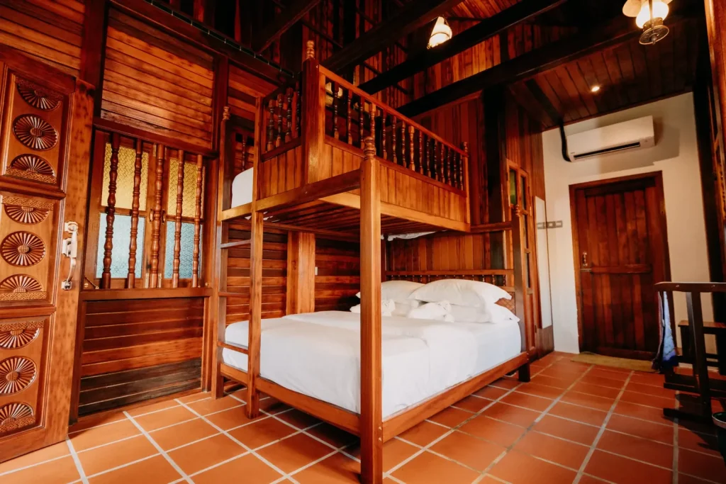 Bilik Lantana Villa Bonda dengan katil queen dan katil bujang dua tingkat dalam rumah kayu